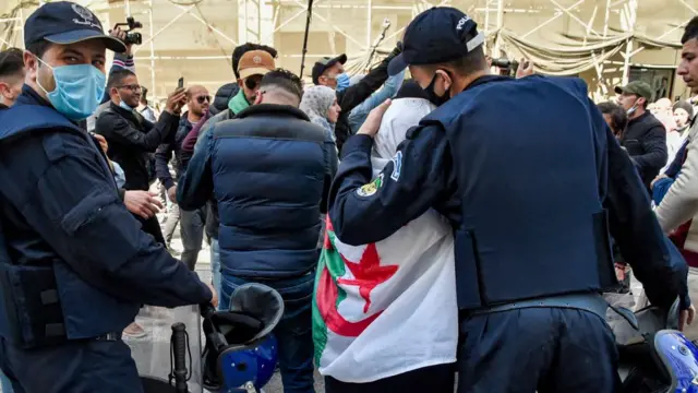 Askari ka tirsan booliska Algeria oo haweenay dadka mudaharaadaya ka mid ah madaxa ka dhunkanaya