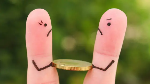 రెండు వేళ్ల మధ్య ఒక కాయిన్