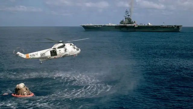 পৃথিবীতে প্রত্যাবর্তন: সাগরে নামার পর চন্দ্রযানটিকে তুলে জাহাজে নিয়ে যাচ্ছে হেলিকপ্টার