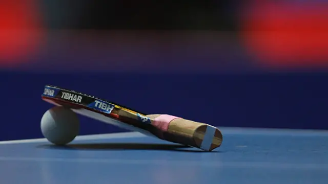 Una pala, una pelota y una mesa de ping-pong.