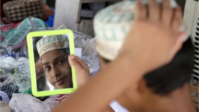 فتى هندي يلبس ثيابا جديدة استعدادا للاحتفال في العيد في الشطر الهندي من إقليم كشمير.