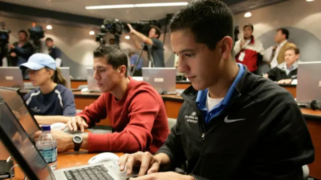 Mahasiswa mengerjakan tugas dengan laptop.