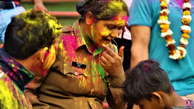 चेहरे पर राधे कृष्ण की छाप बनाने का आग्रह करती एक महिला पुलिसकर्मी