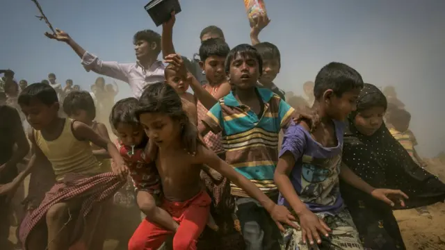 Bangladeş'e göç eden Arakanlı çocuklar yardım paketlerini almaya koşuyor