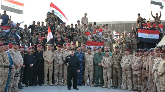 الرئيس العراقي حيدر العبادي رافعاً العلم العارقي بعد اعلان النصر في الموصل