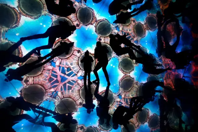 Silhouettes of people standing in a kaleidoscope