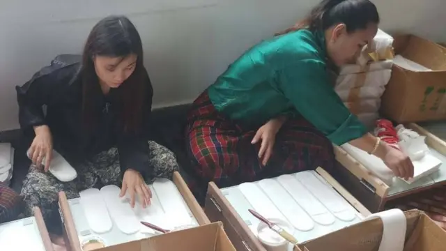 Arya Yogini and female workers make sanitary pads.