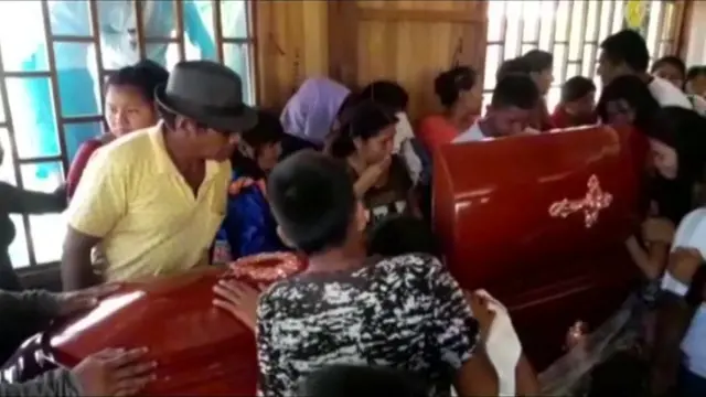 Mourners looks into the open casket of Olivia Arévalo