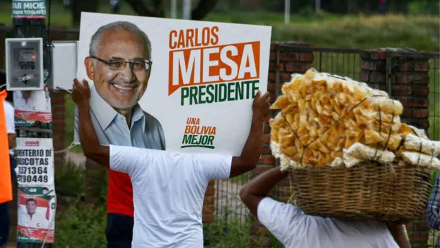 Apoiadores fazem campanha levando cartaz do candidato Carlos Mesa