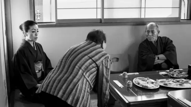 نئے سال کے موقعے پر ایک شخص مافیا باس اور اس کی اہلیہ کو سلام کرتے ہوئے