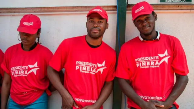 Inmigrantes haitianos con camisetas de apoyo a Piñera en la campaña electoral.