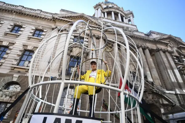 Dame Vivienne Westwood suspendue dans une grande cage à oiseaux à l'extérieur de l'Old Bailey à Londres