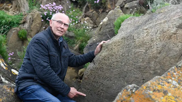 Michel Paugam ao lado da inscrição da rocha