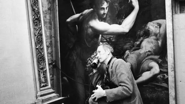 Служитель ночью обходит подземные хранилища в Маноде и пользуется телефоном, подключаемым в розетку в стене