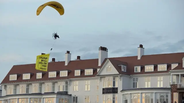 ડોનલ્ડ ટ્રમ્પના આગમન પછી ટર્નબેરી નજીક એક પેરાગ્લાઈડરે આ રીતે વિરોધ પ્રદર્શિત કર્યો હતો