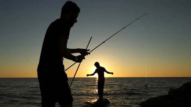Libyans fish from the shore in the eastern city of Benghazi on June 14, 2017
