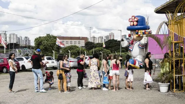 Fila para a bilheteria do circo e, ao fundo, bonecoaviator mrjackpalhaço