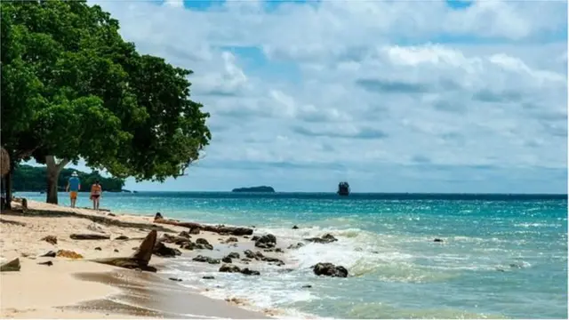 Msururu wa boti ndogo hupita juu ya maji wakati zinaposafirisha watalii wanaokwenda pwani kwenda visiwani kila siku