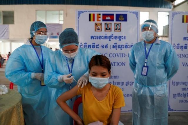 เจ้าหน้าที่ฉีดวัคซีนให้ผู้หญิง ในกรุงพนมเปญ กัมพูชา