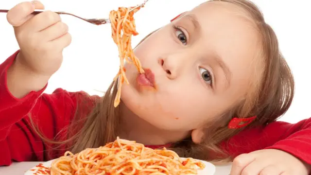 Niña comiendo espagueti con salsa boloñesa
