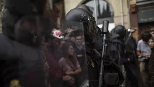 Protesters are reflected on the shields of Spanish police officers outside the Ramon Llull polling station in Barcelona October 1, 2017 during a referendum on independence for Catalonia banned by Madrid.