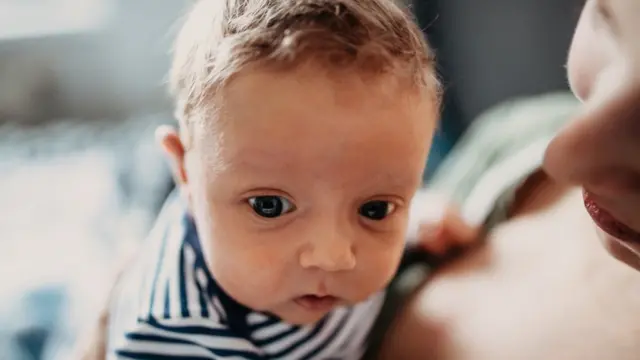 Bebe en manos de su mamá.