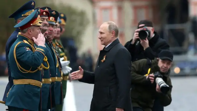 Russian President Vladimir Putin greets members of the military