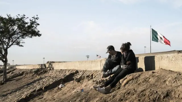 सफ़र शुरू करने के पहले मेक्सिको की सीमा के पार बैठ लोग