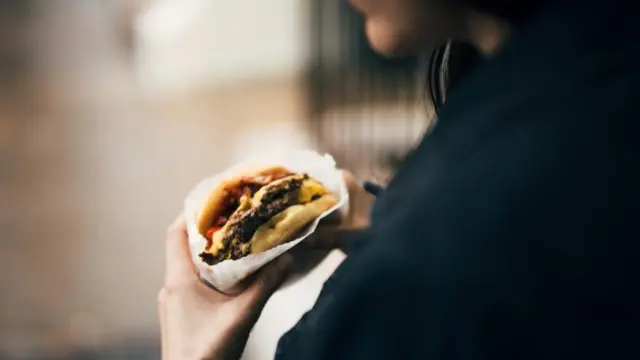 Mujer comiendo una hamburguesa