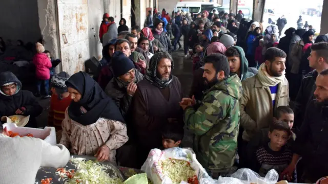 逃离阿勒颇的叙利亚人等候领取救济粮