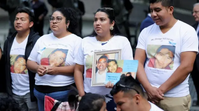 犠牲者の遺影を胸に、式典に参加した人たち