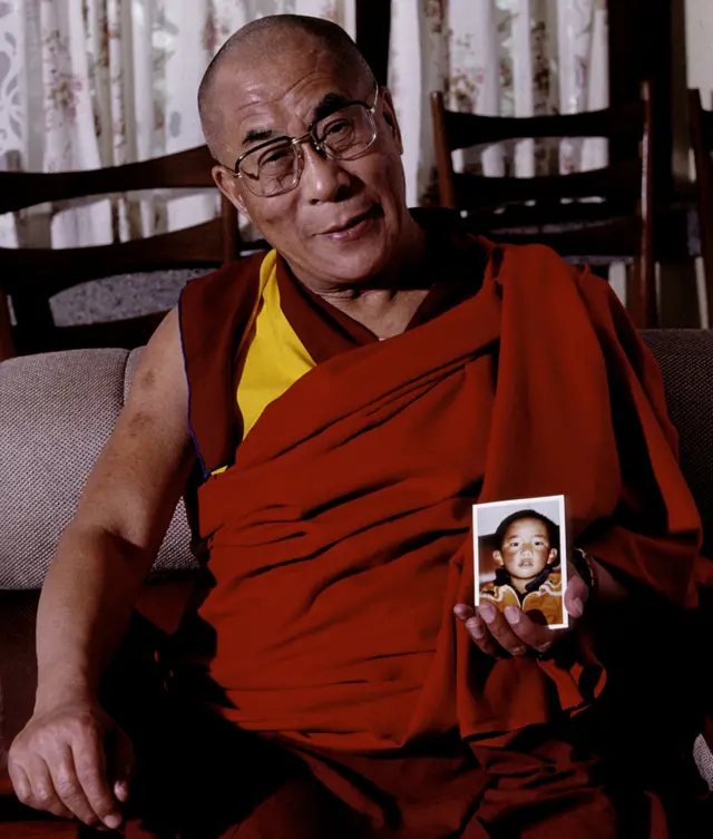 Dalai Lama segurando uma fotoGedhun Choekyi Nyima quando ele tinha 6 anos