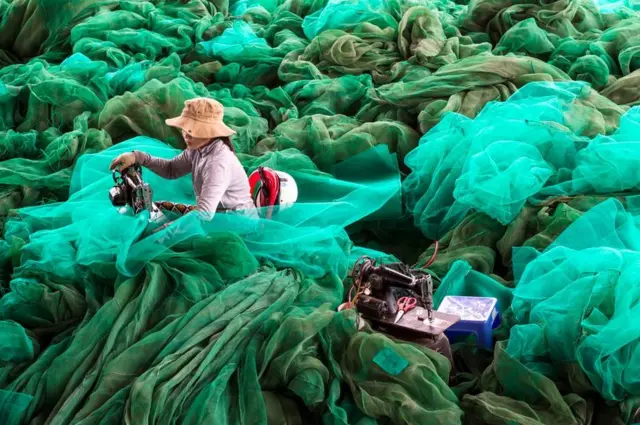 Женщина чинит сеть