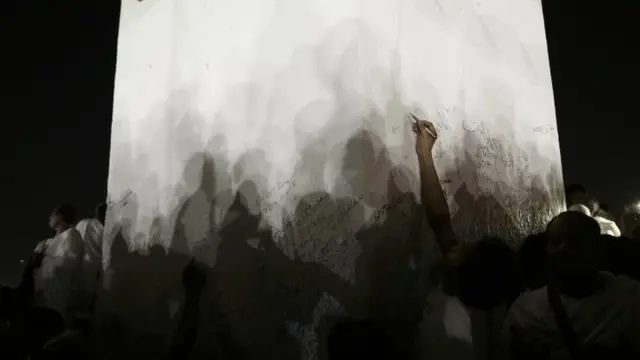 Muslim pilgrims sign their names on a white pillar, where the Prophet Muhammad is believed to have delivered his last sermon (11 September 2016)