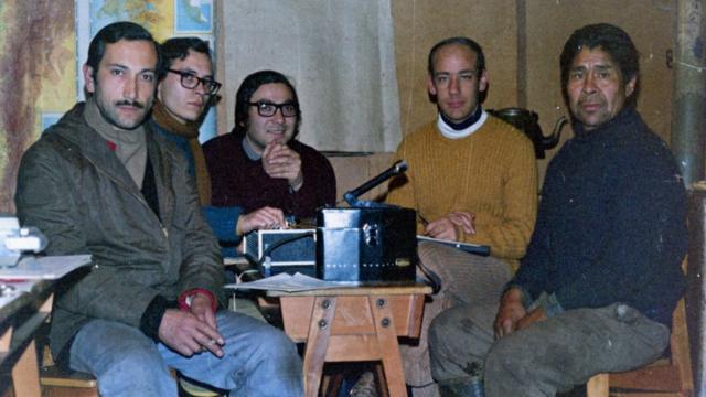 Oscar Aguilera (manipulant l'enregistreur) avec l'équipe de recherche et un membre de Kawésqar (à l'extrême droite) à Puerto Eden, 1975.