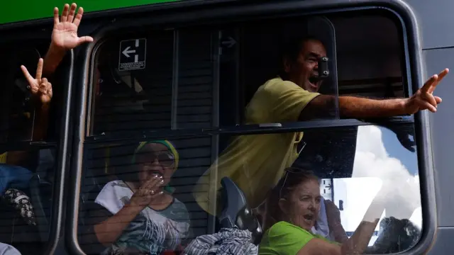 Pessoas detidas sendo transportadas para sede da PF