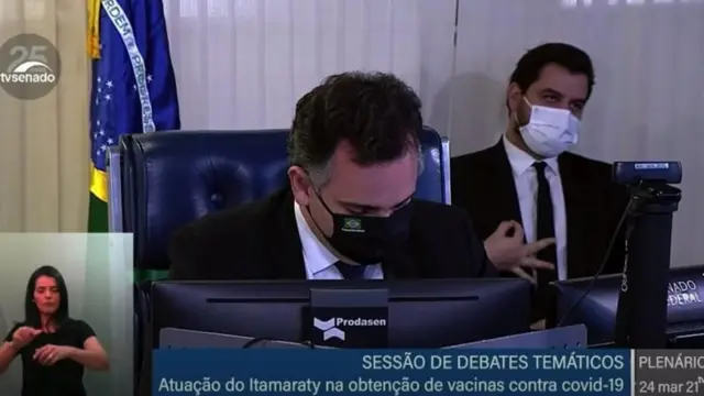 Filipe Martins, que foi assessor de Bolsonaro, aparece em transmissão pela internet de sessão plenária do Senado fazendo um OK invertido com as mãos.