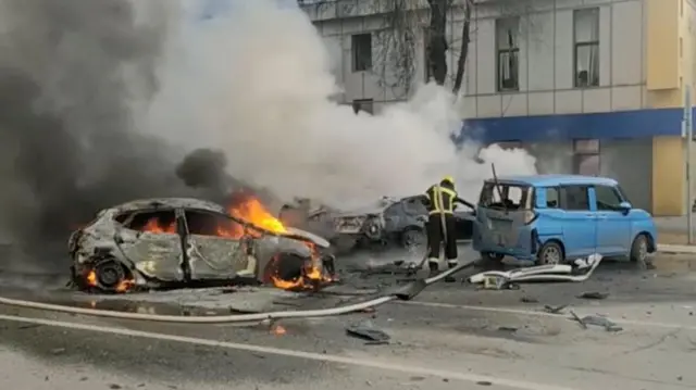 Un pompier tente d'éteindre une voiture en feu après une attaque des forces ukrainiennes contre la ville de Belgorod, selon les informations des autorités russes.