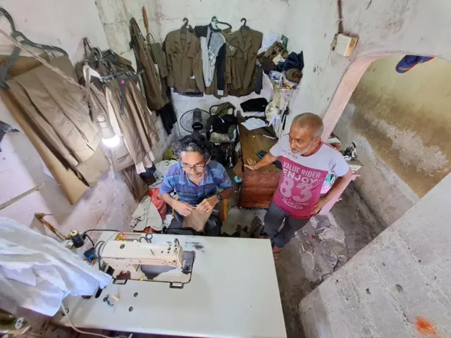  මාලිගාවත්ත ප්‍රදේශයේ ම පොලිස් නිල ඇඳුම් මැසීමේ නිරතවන රාජු සහ ඒ. එහ්.එම්. රිස්වි