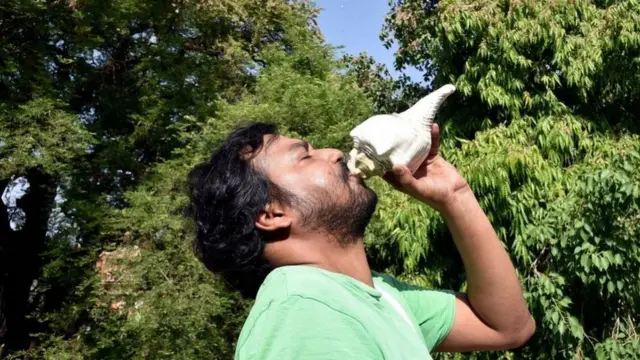 வெட்டுக்கிளியிடமிருந்து தப்பிக்க சங்கு ஊதும் விவசாயி