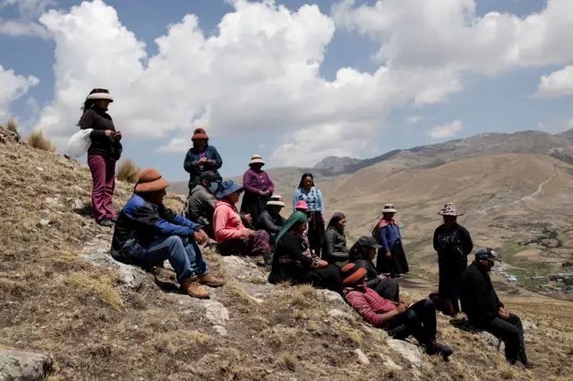 秘鲁民众坐在拉斯邦巴斯矿山附近的山上。当地居民称采矿活动对农作物产量产生了负面影响，并导致牲畜死亡。