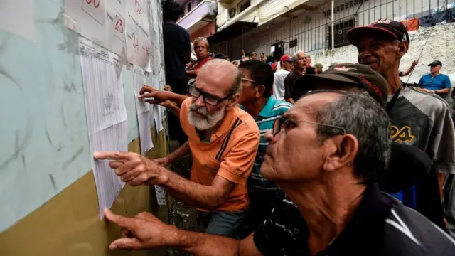 hombres miran padrón electoral