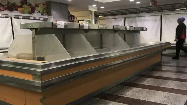 Puestos de verduras y hortalizas vacíos.