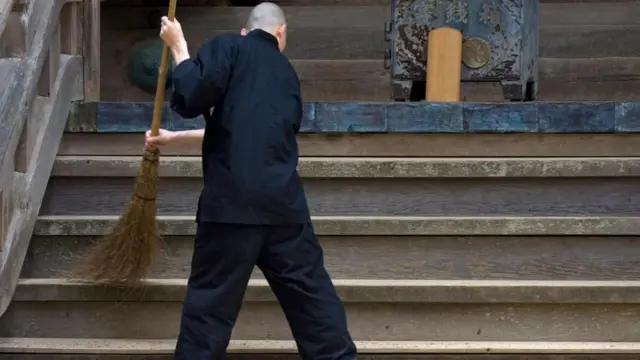 Japonés barriendo con una escoba