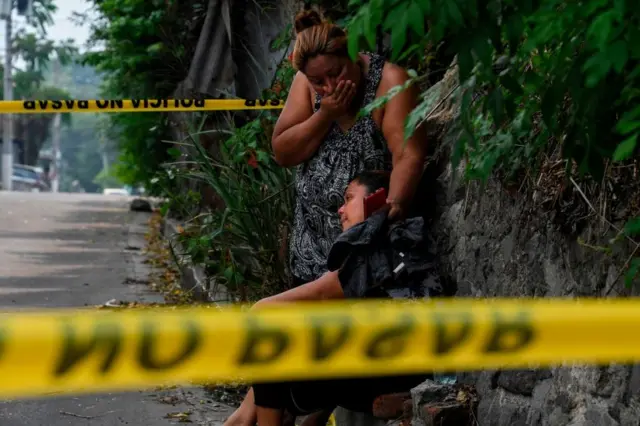 Familiares de un hombre asesinado en Ayutuxtepeque, El Salvador, lloran junto a la escena del crimen el 28 de abril de 2020.