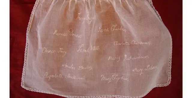 Los nombres conocidos de los niños fueron bordados en un delantal infantil.