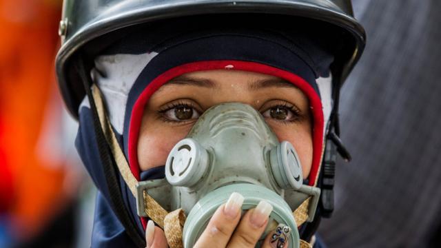 Una manifestante con máscara
