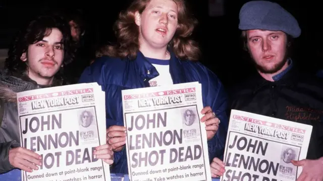 Tres jóvenes sostienen tres periódicos con el titular que anuncia la muerte de John Lennon.