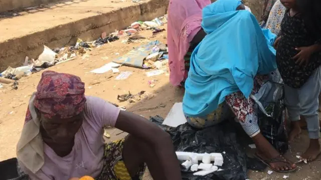 Women wey siddon for ground