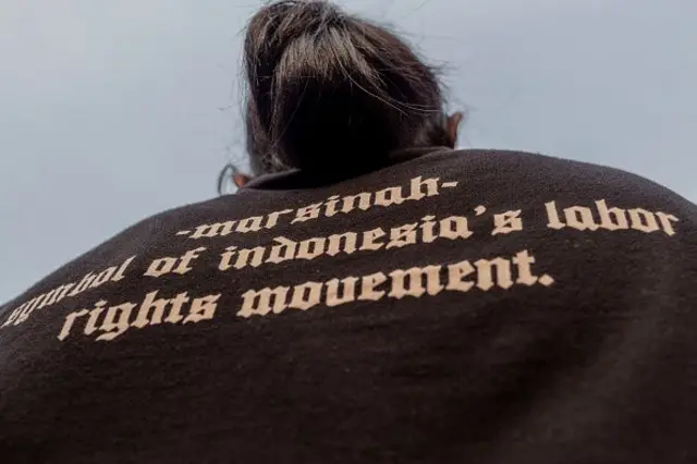 Seorang orator dengan Kaos "Marsinah", seorang pekerja wanita yang terbunuh selama aksinya untuk keadilan tenaga kerja di tahun 90-an bahwa kasusnya masih belum mendapatkan keadilan sampai sekarang